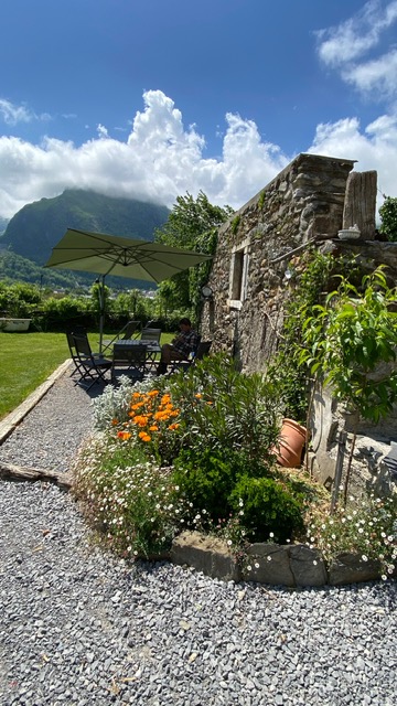 Terrasse de notre maison avec parterre fleuri et vue montagne