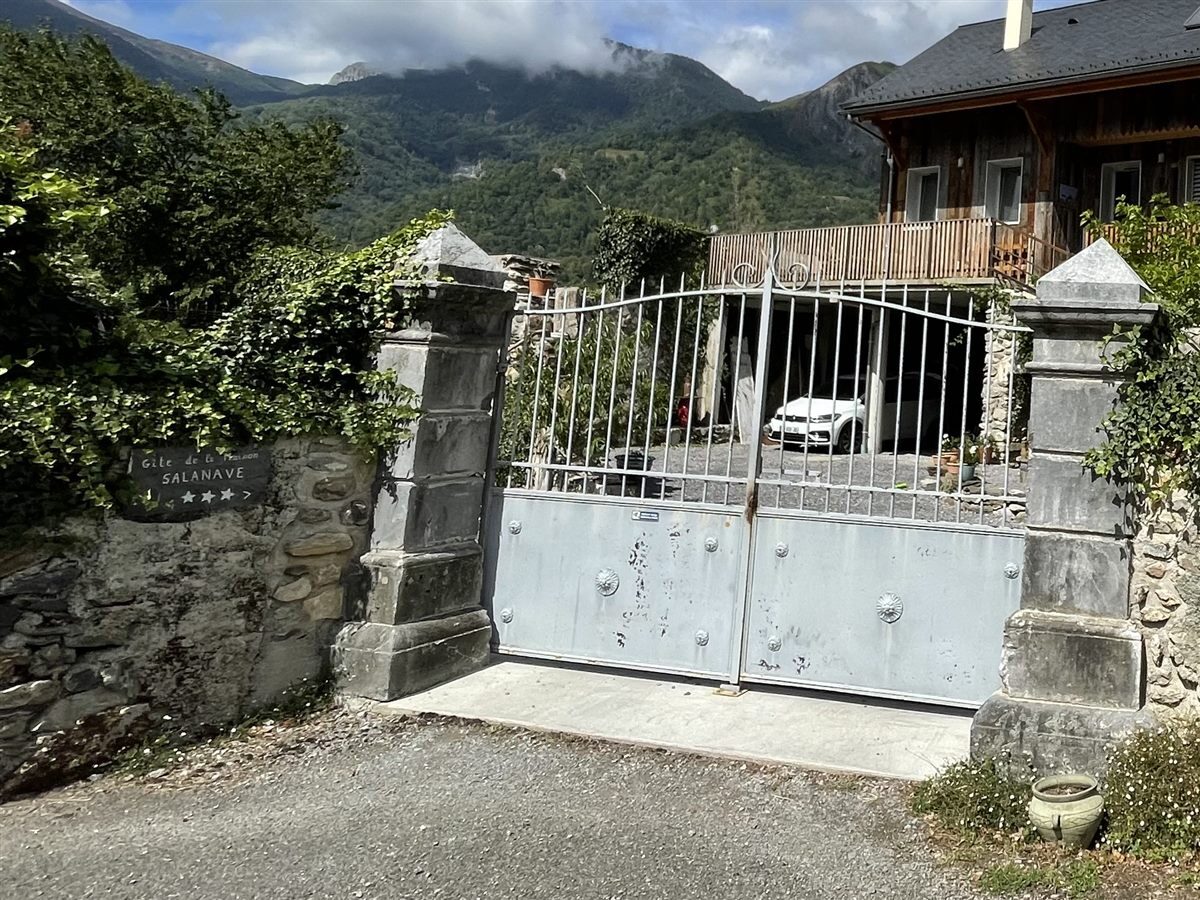 Portail en fer et cour privée fermée du gîte, avec place de parking